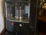 un radiateur noir posé sur une étagère en bois près d'un mur