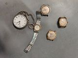 three watches and a watch on a table with a chain around them