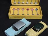 three toy cars in a yellow box on a black surface