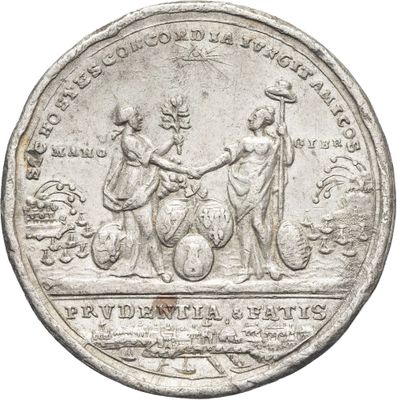 un gros plan sur une pièce d'argent représentant deux femmes se serrant la main