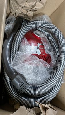 une boîte contenant un aspirateur et un tuyau