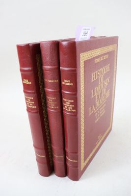 trois livres rouges sont empilés sur une surface blanche