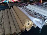many rolls of fabric on a table in a store