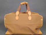 the large tan bag is sitting on a gray surface