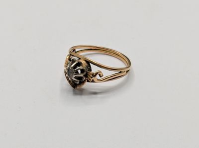 a close up of a gold ring with a black diamond on it