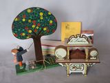 une figurine représentant un homme tenant une horloge devant un arbre