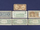 six different types of paper money sitting on top of a blue surface
