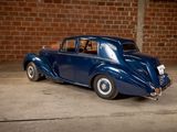 a blue car that is parked in front of a brick wall