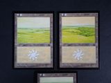 three cards with a picture of a landscape on them on a black surface