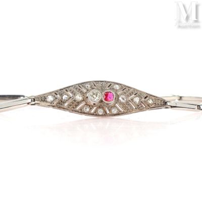 a close up of a silver bracelet with a pink stone in the center