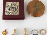 a box that has a ring, ring holder, and other items on it