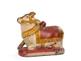 une figurine représentant une vache avec une selle sur le dos