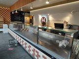 une photo d'un restaurant avec un comptoir et une vitrine