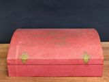 an old red box sitting on top of a wooden table