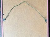 an image of a piece of cardboard with a green string attached to it
