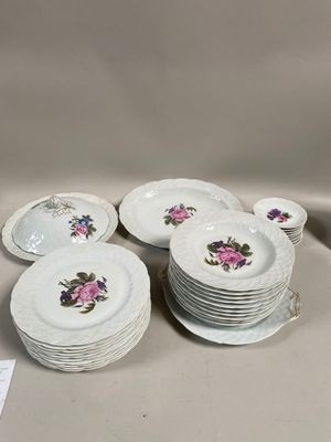 Plusieurs assiettes blanches ornées de fleurs roses sont empilées les unes sur les autres