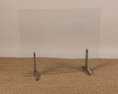 une photo d'une table en verre avec deux pieds en métal posée sur un tapis