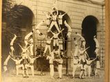 an old photo of a group of men standing on top of each other
