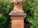 un grand vase orné de fleurs, placé au milieu d'un jardin