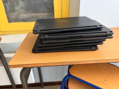 une pile d'ordinateurs portables posée sur un bureau