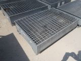 Plusieurs grilles en acier sont empilées les unes sur les autres au sol