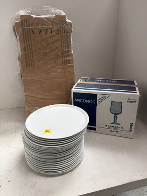 une pile d'assiettes posée sur un plan de travail, à côté d'une boîte d'eau