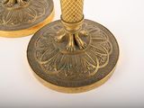 two gold candlesticks sitting on top of each other