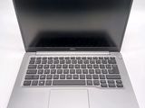 a silver laptop with a black keyboard on a white surface