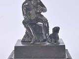 statue of a man sitting on a chair with a dog