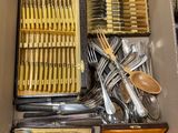 une boîte remplie d'argenterie et d'ustensiles en bois