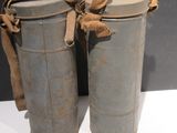 Il s'agit de deux vieilles boîtes en métal auxquelles est noué un ruban marron.
