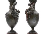 pair of antique bronze vases on wooden bases on a white background