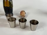 four shot glasses and a vase on the table