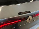 the rear end of a silver car with a sticker on it