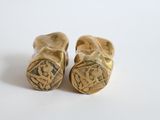 pair of old wooden shoes with a design on them on a white surface