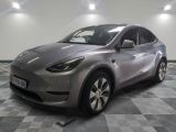 the silver tesla suv is parked on a checkered tile floor