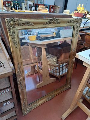 a large mirror sitting on the floor next to a table