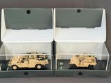 two military vehicles in a display case on a table