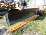 two snow plows that are sitting in the grass