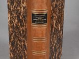 an old book with a brown cover sitting on top of a table