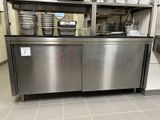 un plan de travail en acier inoxydable sur lequel sont posés des casseroles et des poêles