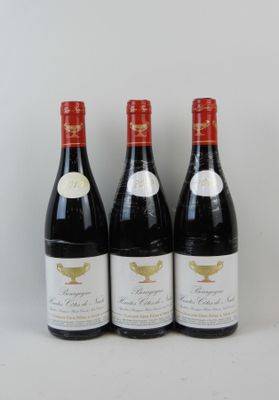trois bouteilles de vin rouge sont alignées sur une surface blanche
