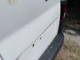 the rear end of a white van parked on the side of a road