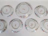 six plates with floral designs are arranged on a white surface