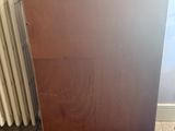 a wooden cabinet sitting next to a radiator in a room