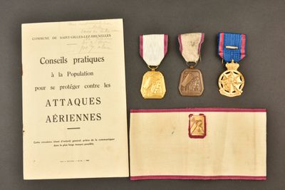 trois médailles et un certificat sont posés sur une table