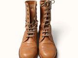 a pair of brown boots that are on a white surface