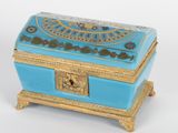 une image représentant une boîte bleue et dorée posée sur une table