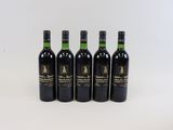 quatre bouteilles de vin sont alignées sur une surface blanche