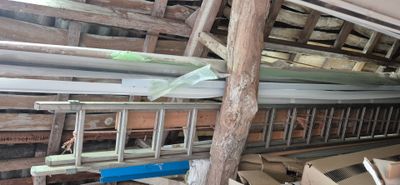une échelle au milieu d'une pièce remplie de planches de bois